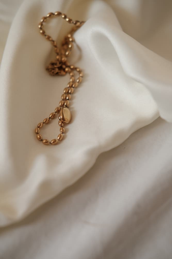 Gold jewelry on softly folded ivory satin